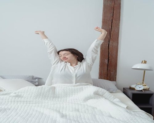 Woman stretching in bed morning routine